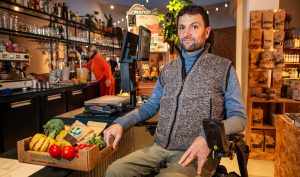 Rolstoelgebruiker Cor Van Damme bij verlaagde toonbank in Knok&Kool