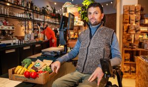 Rolstoelgebruiker Cor Van Damme bij verlaagde toonbank in Knok&Kool